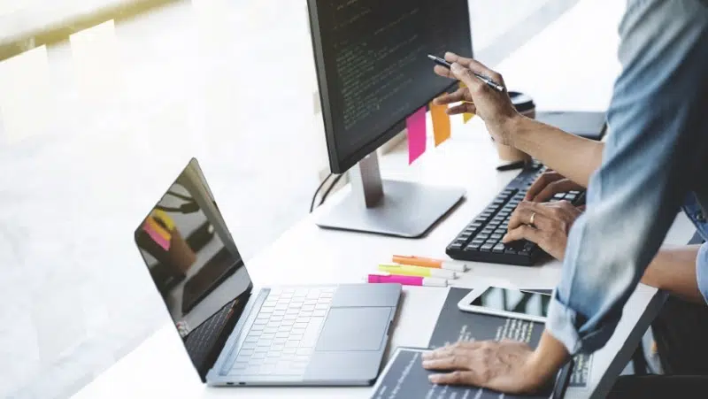 Digital marketing experts working on SEO and data analytics using computers and laptops in a modern office environment